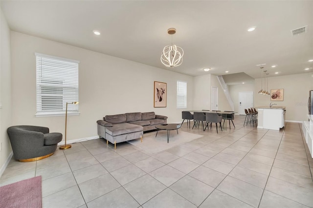 tiled living room with a wealth of natural light and an inviting chandelier