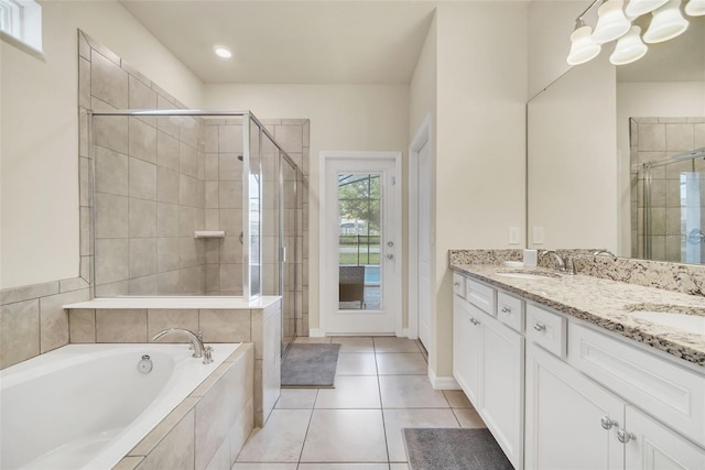 bathroom featuring plus walk in shower, tile patterned floors, and double sink vanity