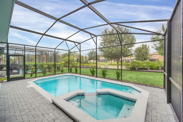 view of pool with an in ground hot tub, a lawn, a patio area, and a lanai