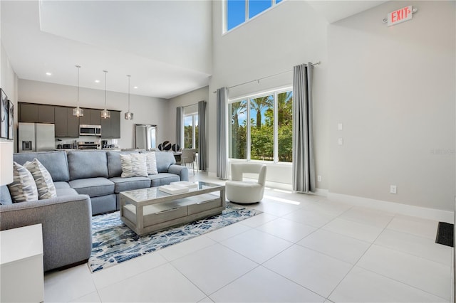 living room featuring light tile patterned flooring and a towering ceiling