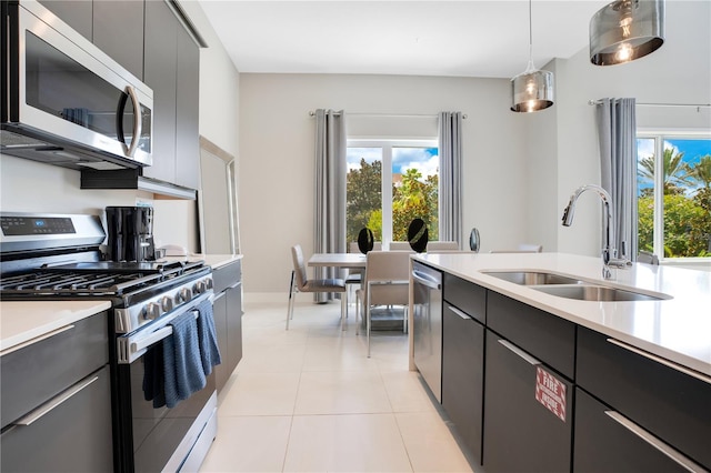 kitchen featuring sink, pendant lighting, stainless steel appliances, and light tile patterned floors