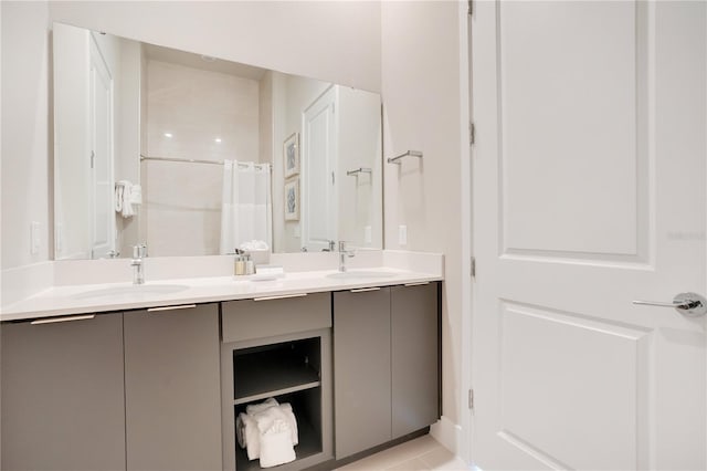 bathroom with tile patterned floors and dual bowl vanity