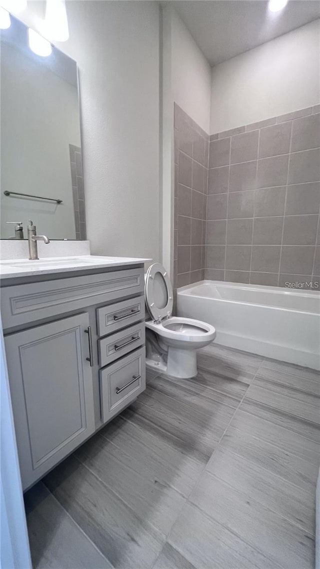 bathroom featuring tub / shower combination, toilet, and vanity