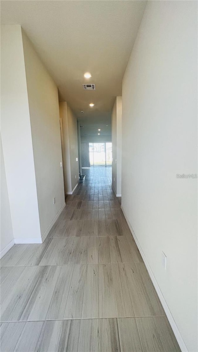 corridor featuring visible vents and baseboards