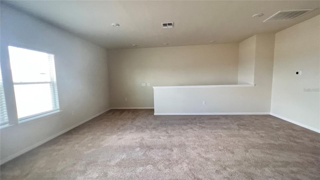 carpeted spare room featuring visible vents and baseboards