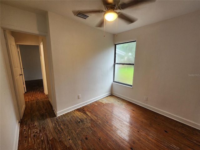 spare room featuring dark wood-type flooring and ceiling fan