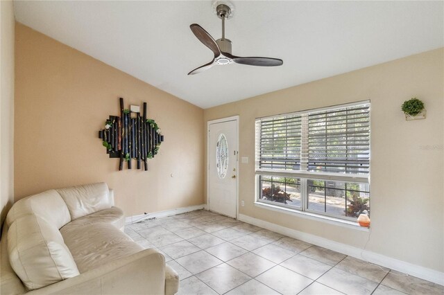 living area featuring ceiling fan, vaulted ceiling, and light tile patterned floors