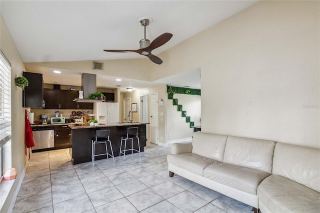 tiled living room featuring sink, ceiling fan, and vaulted ceiling