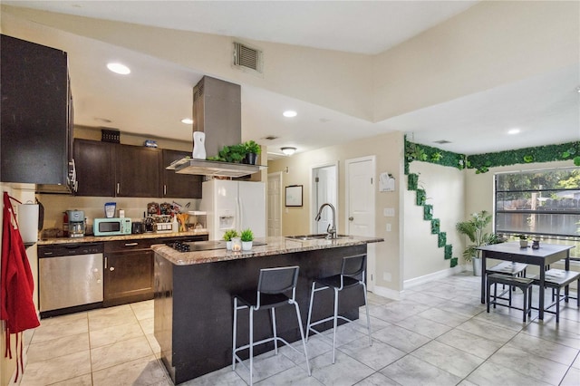 kitchen with white appliances, sink, island range hood, light tile patterned floors, and a kitchen island with sink