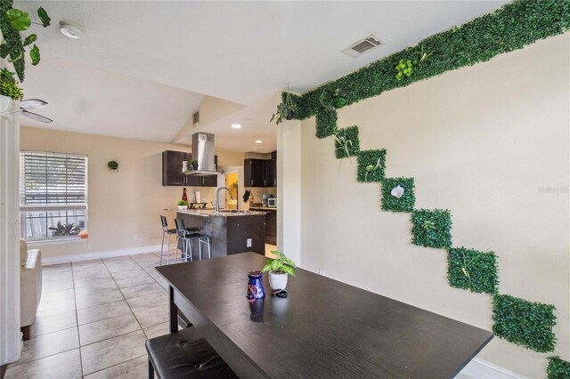 dining room featuring light tile patterned flooring and vaulted ceiling