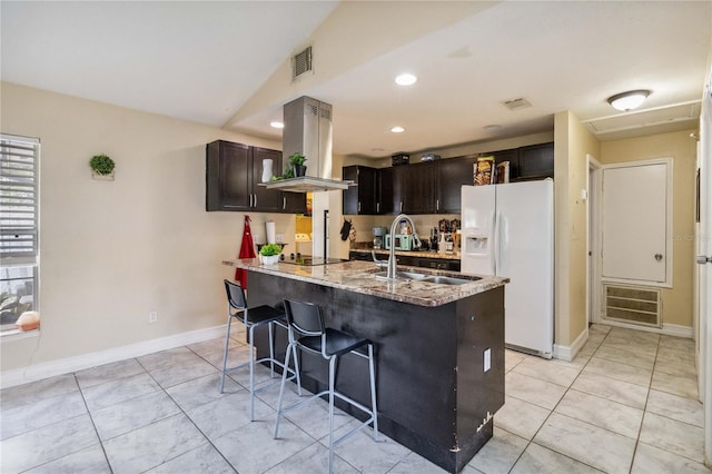 kitchen with light tile patterned flooring, white refrigerator with ice dispenser, light stone counters, island range hood, and lofted ceiling