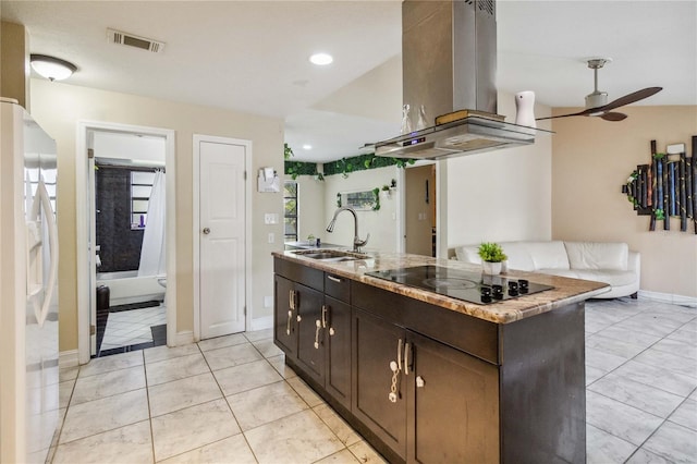 kitchen featuring dark brown cabinetry, black electric stovetop, island range hood, white fridge with ice dispenser, and a center island with sink