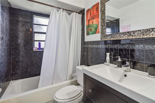 full bathroom with tile walls, vanity, toilet, and shower / tub combo with curtain