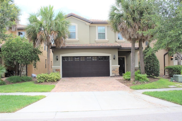 view of front facade with decorative driveway, a tile roof, and stucco siding