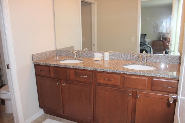 bathroom with double sink vanity and toilet