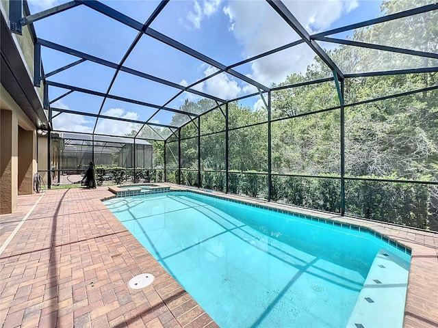 view of pool featuring a lanai, a patio, and an in ground hot tub