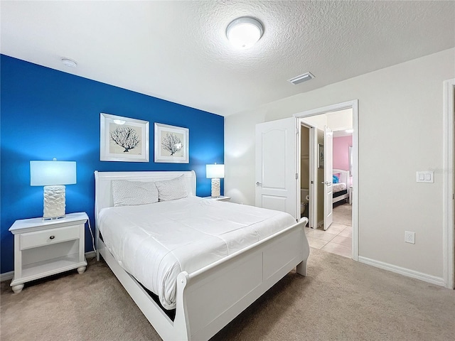 bedroom featuring light carpet and a textured ceiling