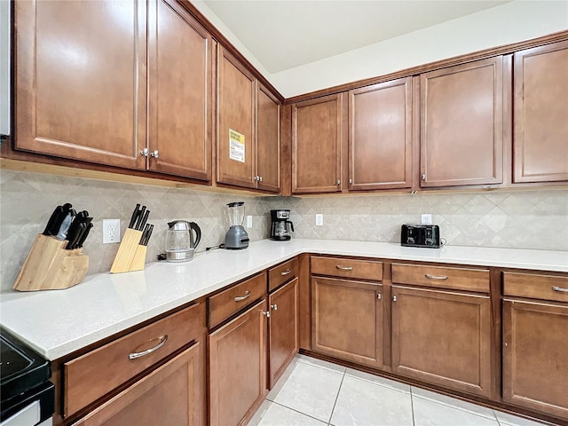 kitchen with tasteful backsplash and light tile patterned flooring