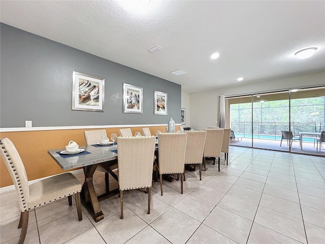 tiled dining room with a textured ceiling