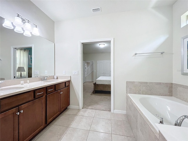 bathroom with vanity, tile patterned flooring, and tiled tub