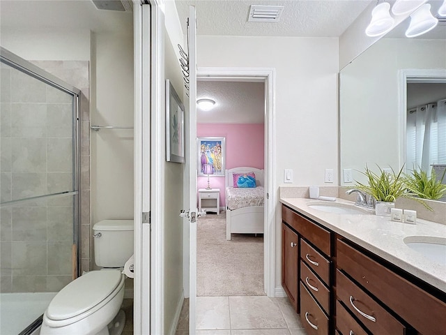 bathroom with vanity, a textured ceiling, tile patterned floors, toilet, and walk in shower