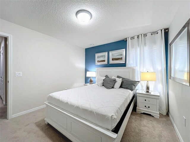 carpeted bedroom featuring a textured ceiling