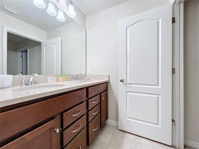 bathroom with tile patterned floors, vanity, and a textured ceiling