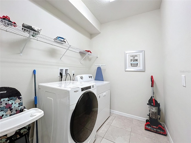 laundry room with independent washer and dryer and light tile patterned floors