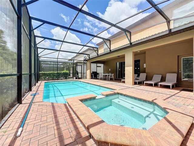 view of swimming pool featuring a patio, glass enclosure, and an in ground hot tub