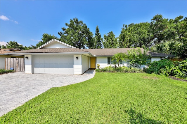 single story home featuring a garage and a front lawn