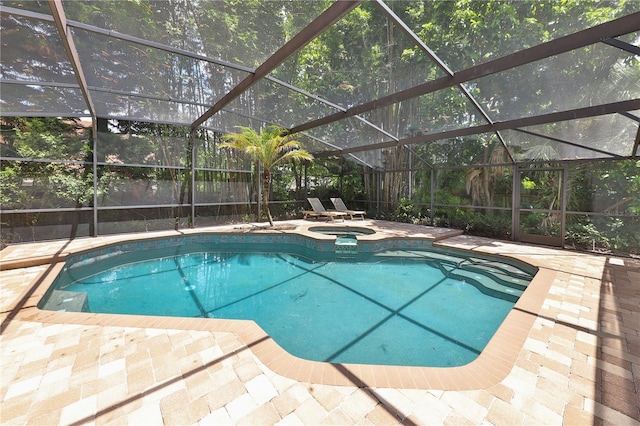 view of pool with an in ground hot tub, a patio, and glass enclosure