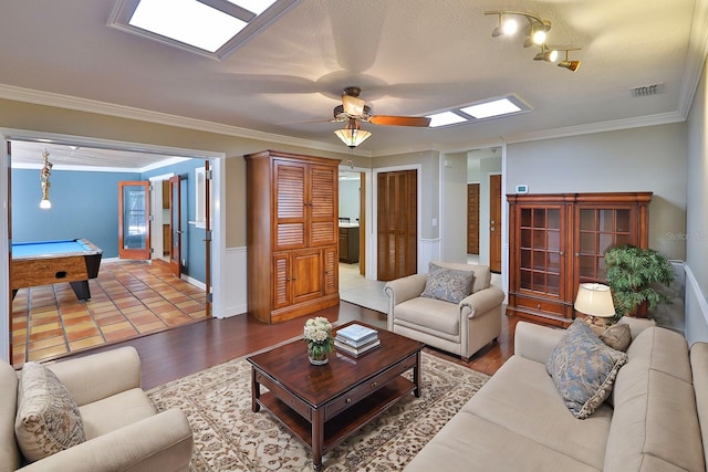 living room with wood-type flooring, a textured ceiling, ornamental molding, and pool table