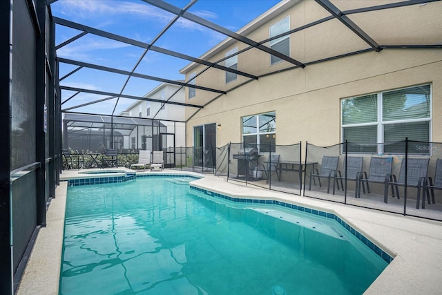 view of pool featuring an in ground hot tub, a grill, glass enclosure, and a patio area