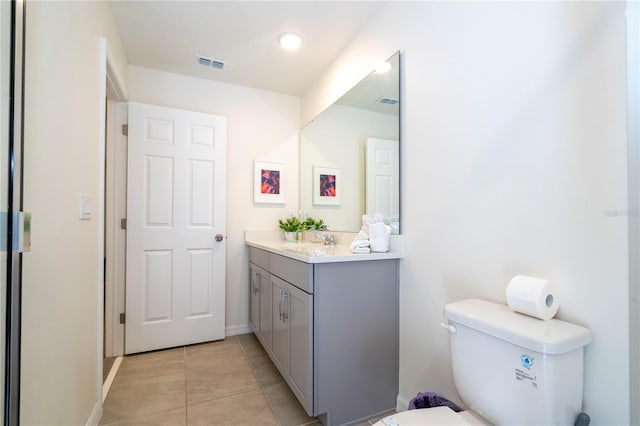 bathroom featuring vanity, tile patterned floors, and toilet