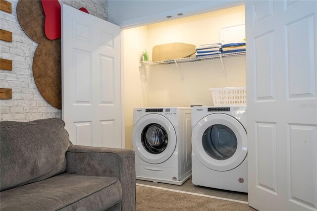 washroom with washer and dryer and light tile patterned floors