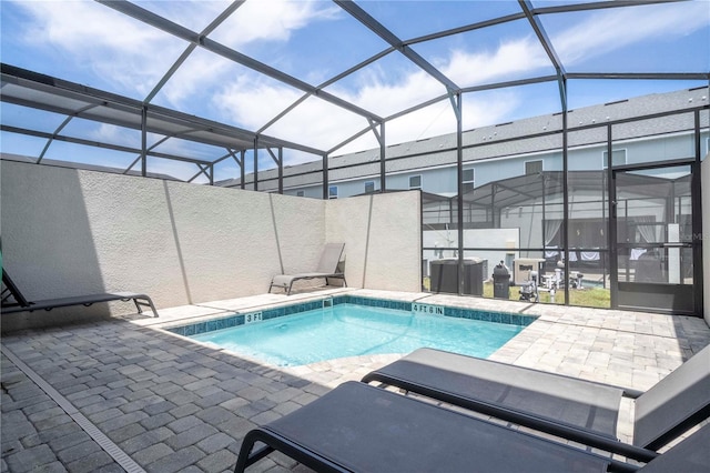 view of swimming pool featuring a patio and glass enclosure