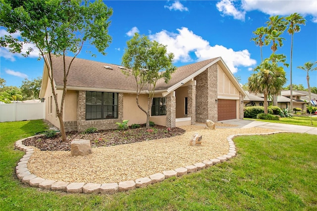 view of front of house featuring an attached garage, fence, concrete driveway, and a front yard