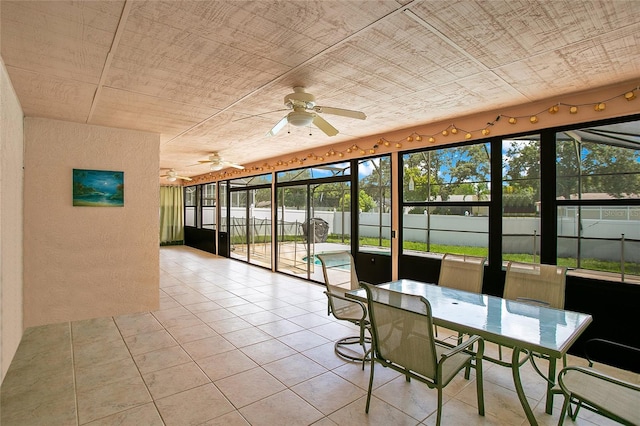 unfurnished sunroom featuring a healthy amount of sunlight and ceiling fan