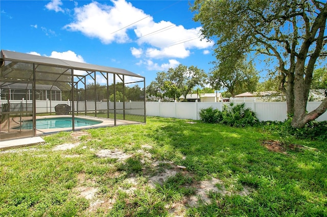 view of yard featuring a fenced in pool and glass enclosure