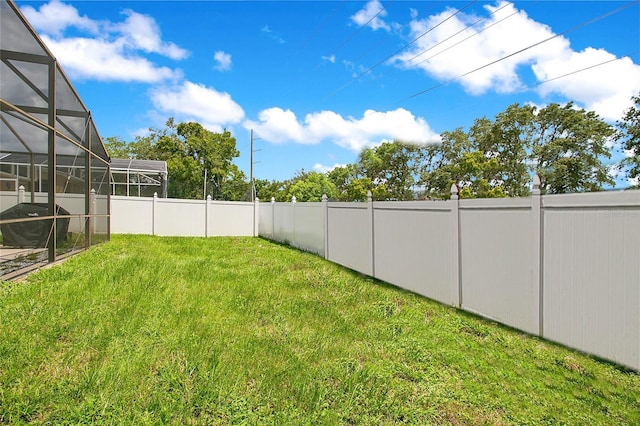 view of yard featuring glass enclosure