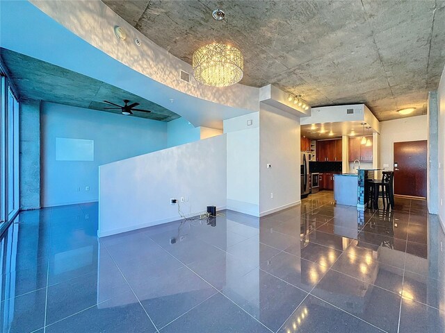 unfurnished room featuring ceiling fan with notable chandelier