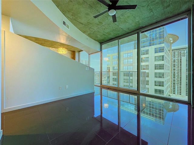 spare room featuring floor to ceiling windows and ceiling fan