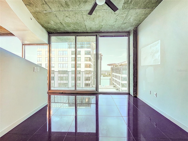 unfurnished room with ceiling fan, a water view, plenty of natural light, and floor to ceiling windows