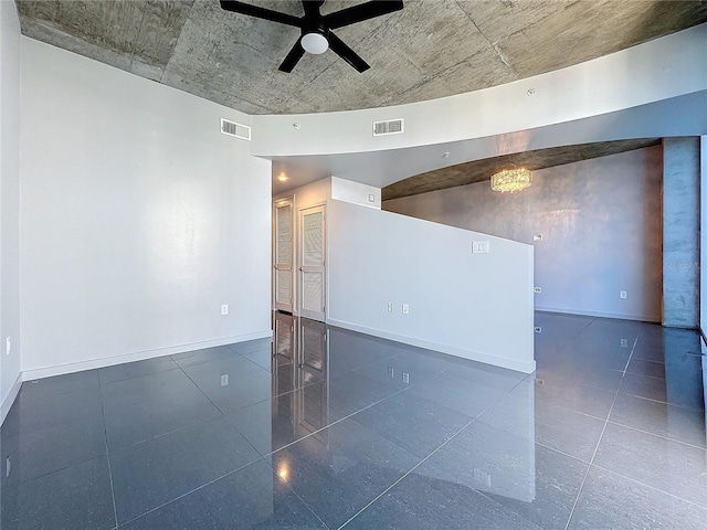 empty room with ceiling fan with notable chandelier