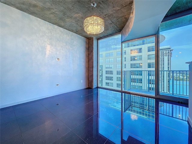 unfurnished room with a wall of windows and a notable chandelier