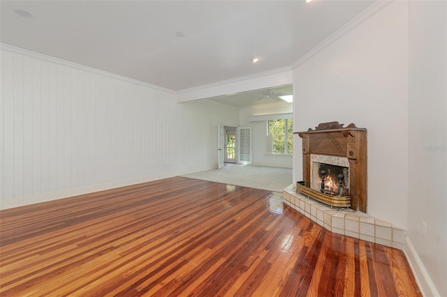 unfurnished living room with ceiling fan, a fireplace, ornamental molding, and wood-type flooring