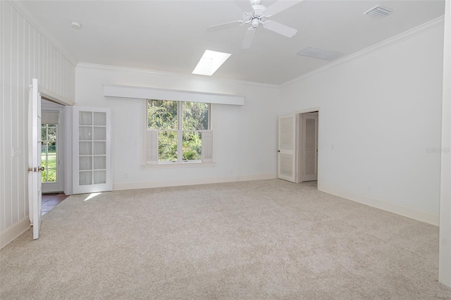 carpeted spare room with crown molding, ceiling fan, and plenty of natural light