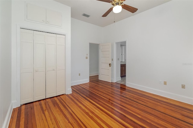 unfurnished bedroom featuring wood-type flooring, a closet, and ceiling fan