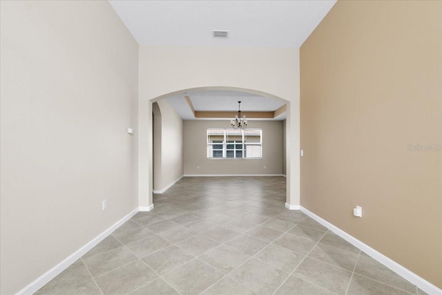 interior space featuring light tile patterned floors, a raised ceiling, and a chandelier