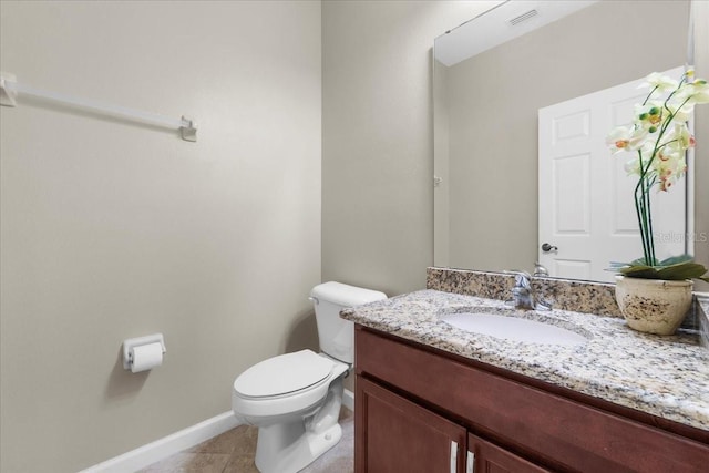 bathroom featuring vanity, tile patterned floors, and toilet